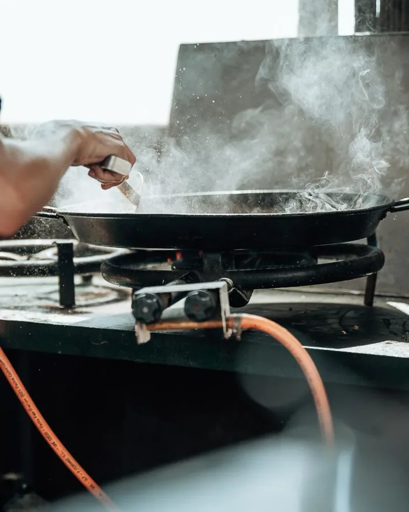 Paella al fuego en la cocina de playa